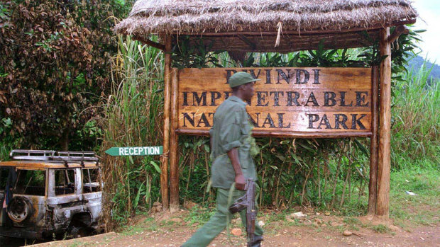 A Ugandan soldier walks past the entrance of the Bwindi Impenetrable National Park the week of the murders.