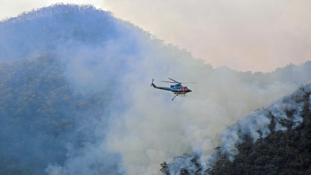 A helicopter waterbombing fires on NSW's south coast in mid-August.