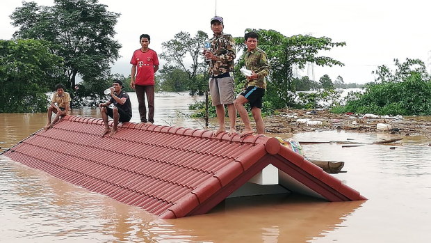 Lao villagers are stranded on a roof of a house due to floodwaters after the dam collapsed 