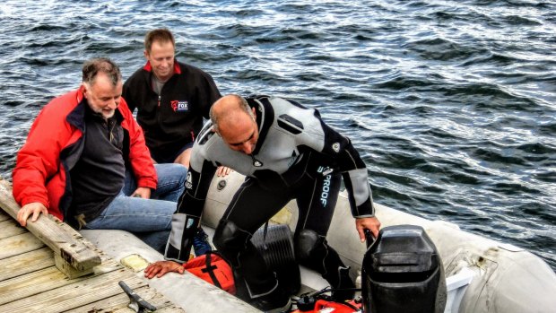 Australian Navy Vice-Admiral Mike Noonan, centre, with Greg DeAscentis, right, and Captain Cook's Ships Foundation President Andrew Elvin pushing off from Elm St Pier, Newport, headed to the dive boat off Goat Island, New York.  