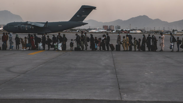 Evacuees wait to board a C-17 at Hamid Karzai International Airport in Kabul.