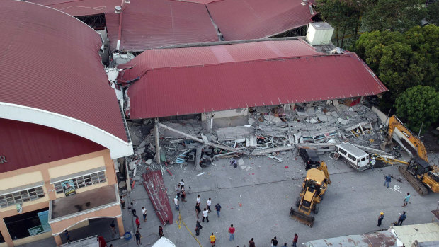 Workers continue rescue efforts for people still trapped inside a collapsed building at Porac town.