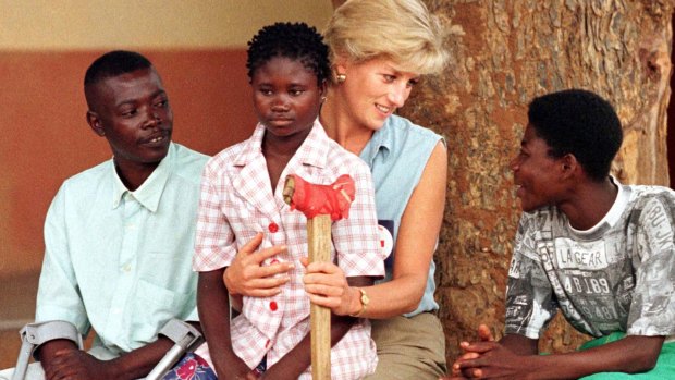 Diana on a visit to Angola talks to victims of landmines in 1997.