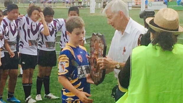 A young Sam Walker collecting some silverware after an under-12s grand final.