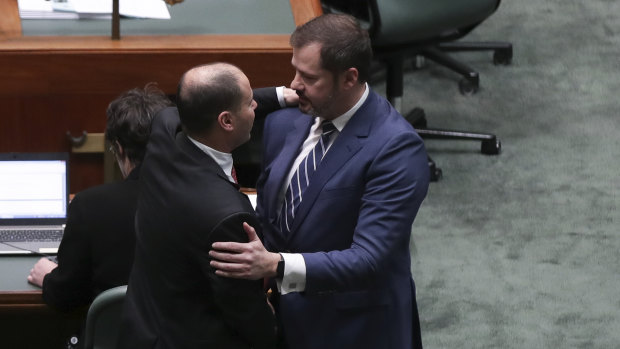 Josh Frydenberg and Ed Husic embrace on the floor of Parliament after condemning a divisive speech given by Fraser Anning.