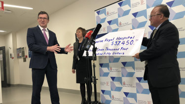 Federal minister Alan Tudge (left) was presented with a donation by Di Sanh Duong (right) in 2020.