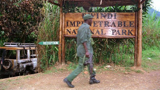 A Ugandan soldier walks past the entrance of the Bwindi Impenetrable National Park the week of the murders.