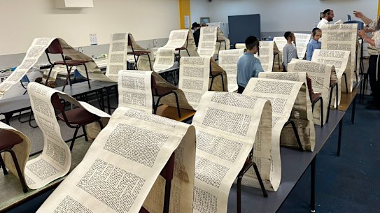 Members of the Adass Israel community inspect Torah scrolls damaged in Friday’s synagogue firebombing.