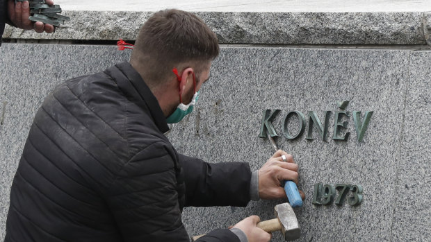 A worker removes a sign from the pedestal of the statue of Soviet World War II commander Marshall Ivan Stepanovic Konev after it was removed from its site in Prague.