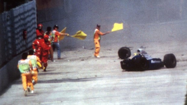 Race officials run towards Ayrton Senna's car after he crashed at Imola in 1994.