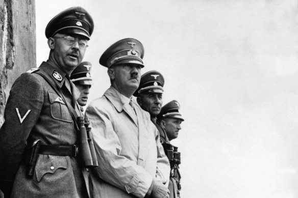 Heinrich Himmler (left) stands with Adolf Hitler to observe a parade of Nazi Stormtroopers in 1940. 