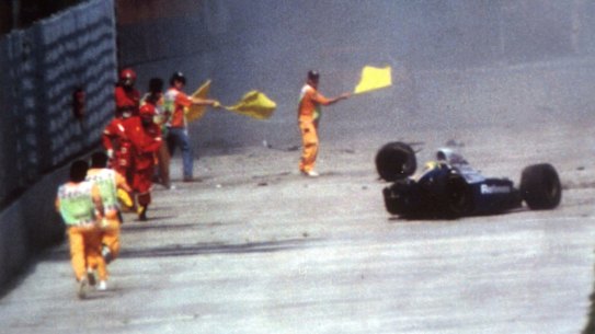Race officials run towards Ayrton Senna's car after he crashed at Imola in 1994.