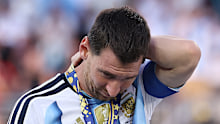 Lionel Messi of Argentina sheds tears as he watches Spain players celebrate winning the World Cup final.