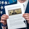 Treasury Secretary Scott Bessent holds up an image of the proposed $250 note.