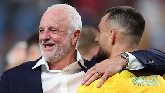 Socceroos coach Graham Arnold celebrates with Bailey Wright after the Denmark win.