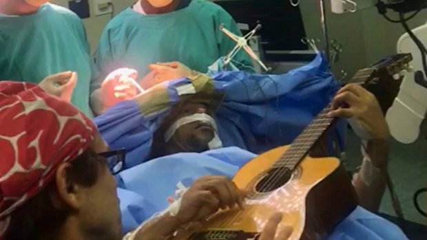 South African musician, Musa Manzini, plays a guitar during brain surgery in Cape Town.