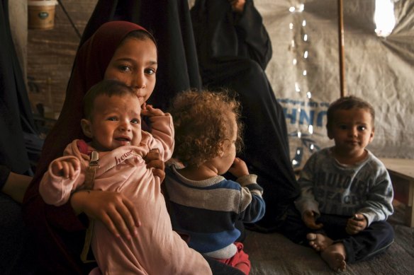Australian Maysa Assaad, 9, holding Shayma Assaadâ's daughter Mariam (2nd from left) in al Hawl camp.