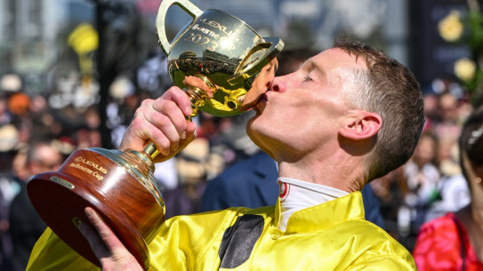 Jockey Mark Zahra kisses the cup after winning the Melbourne Cup on Without A Fight.
