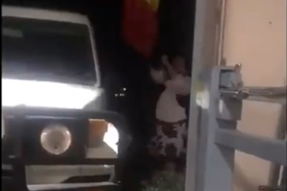 A scene from viral video showing Karen Ridge attempting to remove the Aboriginal flag in2019.