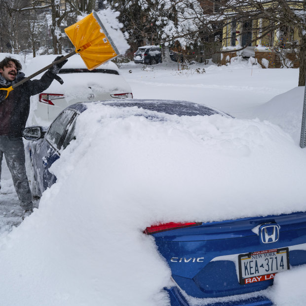 Christian Parker of Buffalo shovels snow off his car in the Elmwood Village neighbourhood on Monday.