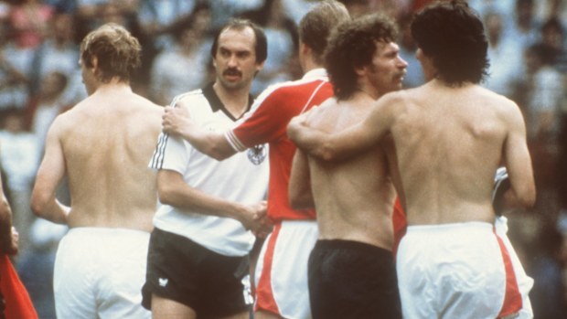 Friendly hugs and handshakes after the match mark a collusive game between Germany and Austria in 1982.