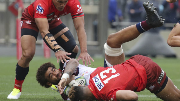 Lukhan Salakaia of the Reds is tackled by the Sunwolves during their Super Rugby match in Tokyo on Saturday.