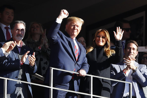 President Donald Trump and first lady Melania Trump wave to the crowd at the game between the LSU Tigers and the Alabama Crimson Tide in Tuscaloosa, Alabama. 