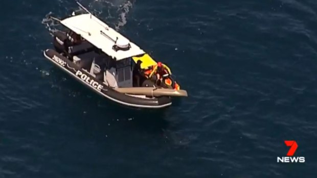 A kayak is retrieved on the Sunshine Coast after the kayaker was knocked into the water by a tiger shark.