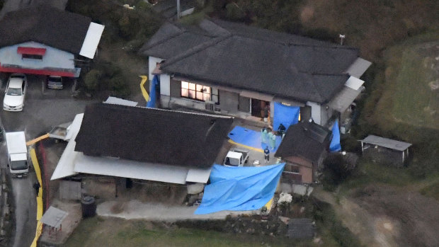 Blue plastic sheets cover the site where six bodies believed to be members of a family were found at a farmhouse in Takachiho.