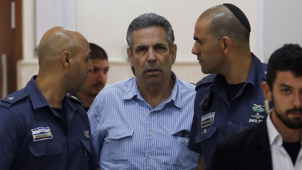 Former Israeli cabinet minister Gonen Segev, centre, escorted by prison guards as he arrives at court in Jerusalem in July 2018.