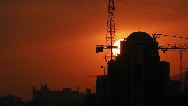 Buildings under construction are silhouetted against the setting sun in Tehran. Iran has threatened to increase its uranium enrichment above levels permitted by the 2015 accord.