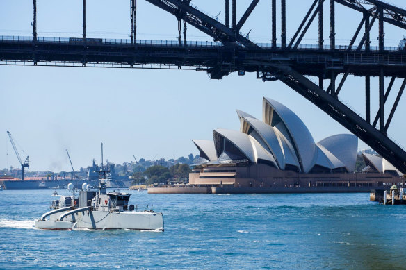 The uncrewed surface vessel Sea Hunter sails under the Sydney Harbour Bridge as part of an October training exercise. 