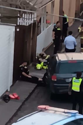 An image from police shows the officer lying on the ground after he had been hit by the SUV and shot the car’s occupants. Police have blurred the faces of the officers.