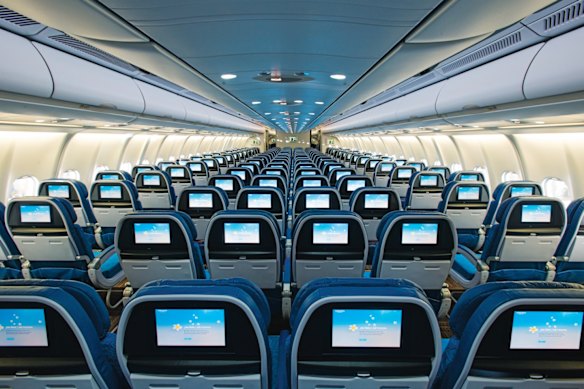 The main cabin, and the entertainment screens, on a Hawaiian Airbus A330.