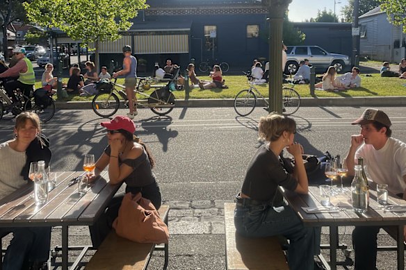 Patrons at the Wine Corner Store and on the nature strip on Canning Street in Carlton North. 