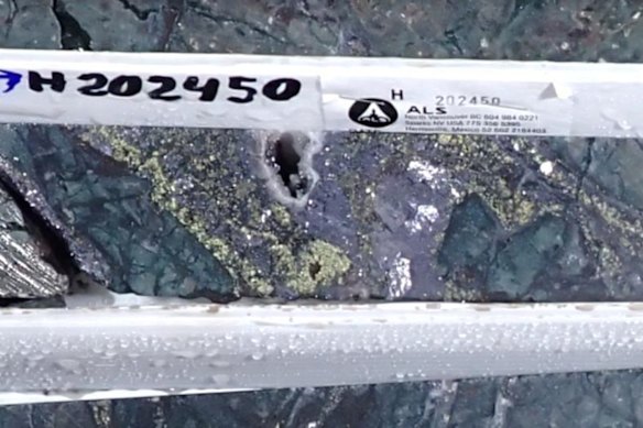 Cut diamond drill core from the headline hole, from 102.7 to 103.0m downhole depth, showing semi-massive coarse-grained lead sulphide (grey), with zinc sulphide (pale yellow), minor copper sulphide (bright yellow) and quartz (white).