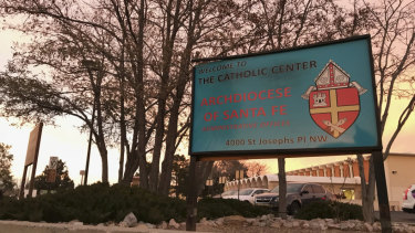 The sun sets on a sign in front of the Archdiocese of Santa Fe offices in Albuquerque. The archdiocese is in bankruptcy proceedings as a result of the abuse scandal involving 70 clergy members.