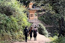 A classic Bhutanese structure featuring intricate wooden window frames and a tiered roof on the trail to the Tiger’s Nest Monastery.