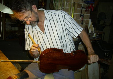 Graham Caldersmith varnishes a violin.