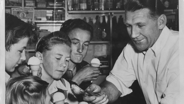 Jack Dyer serving icecream to young admirers in his South Melbourne Shop