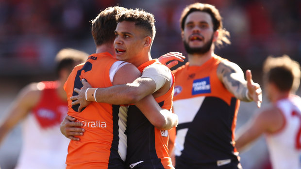 Lachie Whitfield celebrates with Giants teammates after kicking a goal against the Swans.