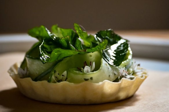 Smoked eggplant tart with cucumber, chive flowers and fried curry leaf.