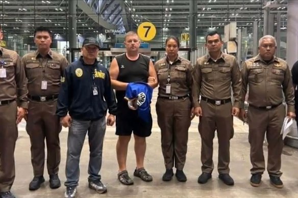 Simon Peter Carman (fourth from the left, in singlet) under arrest in Thailand.
