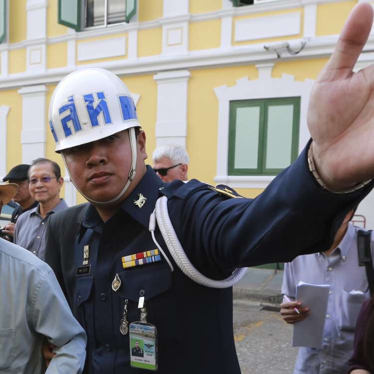 Thai social critic Sulak Sivaraksa is escorted outside a military court earlier this year, when the latest lese-majeste charges against him were dropped.