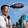 Scott Yung speaking during the federal election campaign, with an advertising blimp hovering overhead.