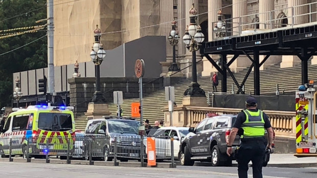Dramatic scenes at Spring Street as a man was arrested after trying to set a white vehicle alight outside State Parliament. 