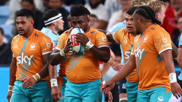 Moana Pasifika players celebrate a try in their first win of the season.