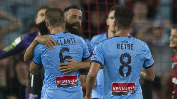 Fated: Alex Brosque is mobbed as Sydney FC launch their comeback.