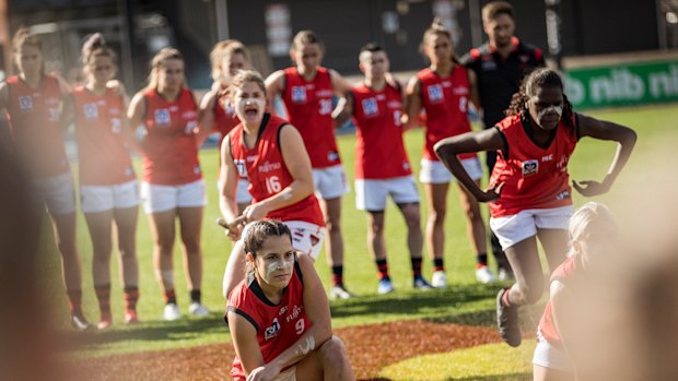 Essendon VFLW players, Indigenous and non-indigenous, participate in a Unity dance prior to the VFLW match between Richmond and Essendon at Punt Road in 2018.