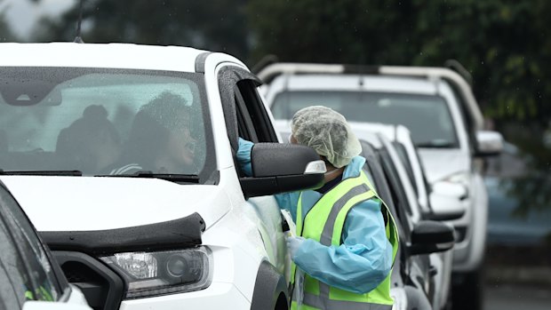 People line up in their cars to be tested for coronavirus at the pop-up civic testing clinic at the Crossroads Hotel in Casula on Saturday morning.